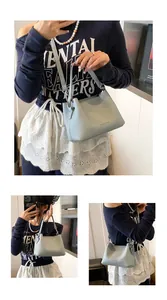 Détail du sac seau bleu clair avec texture litchi et crochets en argent