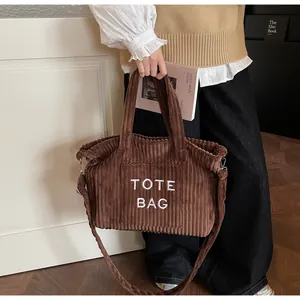 Detail of brown corduroy tote bag with TOTE BAG embroidery and adjustable shoulder strap