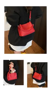 Détails du sac à bandoulière rouge en cuir grainé avec inscription FASHION & BAGS