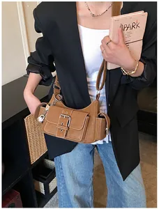 Detailansicht einer braunen Retro-Tasche mit Cargotaschen und Metallschnallen