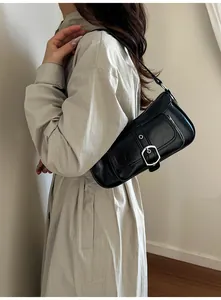 Detail of vintage black faux leather shoulder bag with silver buckle and textured finish