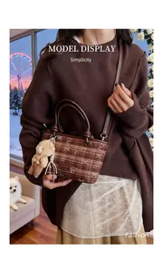 Détail du sac seau à carreaux avec breloque ours et bandoulière réglable pratique