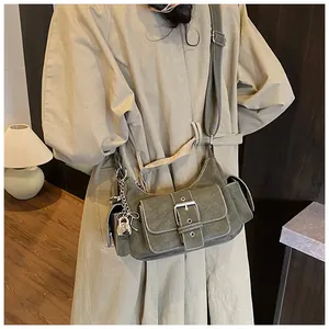 Détail du sac baguette vert armée avec plusieurs poches et boucles métalliques argentées