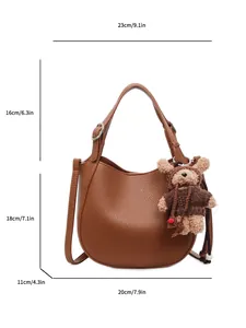Brown litchi grain bucket bag with a cute bear charm and size markings for scale