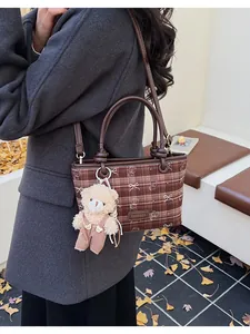 Détail du sac seau à carreaux marron avec imprimé ours et breloque en peluche