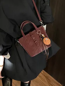 Sac seau chic en similicuir marron foncé avec poignée et breloque biscuit en peluche