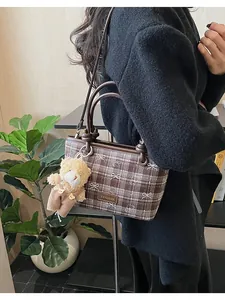 Détail du sac seau vintage à carreaux marron avec imprimé ours et breloque en peluche