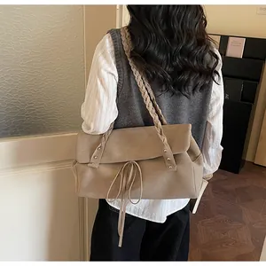Dettaglio della borsa tote in camoscio kaki con doppi spallacci intrecciati e lacci sottili