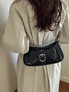 Minimalist black baguette shoulder bag with glossy finish and silver buckle detail