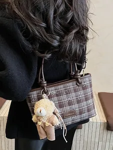 Sac seau à carreaux marron avec breloque ours et poignée en cuir porté en bandoulière