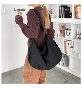 Détail du grand sac cabas nuage noir en nylon porté à l'épaule pour femme