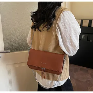Détail du sac en cuir caramel avec bandoulière chaîne et logo Maven & Chic