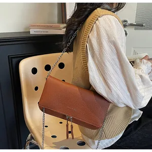 Détail du sac en cuir grainé caramel avec chaîne argentée et longs glands à franges