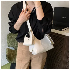 Détail du sac hobo en cuir ivoire avec une petite pochette amovible sur la bandoulière