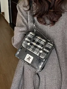 Sac fourre-tout à carreaux chic avec écusson ours rétro porté par un mannequin en blazer gris