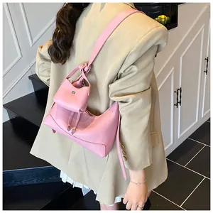Ensemble sac baguette en cuir rose avec mini pochette assortie et détail de la bandoulière