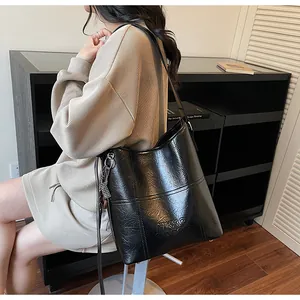 Detail der schwarzen Bucket-Bag aus Wachsleder mit weißen Nähten und Silberbeschlägen