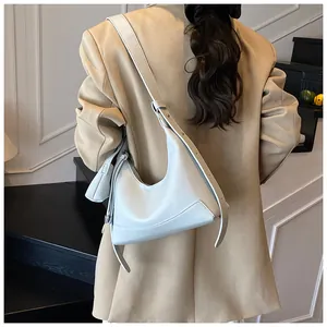 Détail du sac hobo en cuir bleu clair avec large bandoulière réglable sur le mannequin