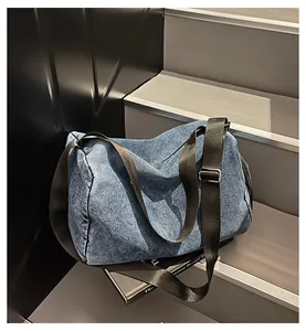 Detail view of large denim tote bag on steps showing adjustable strap and washed texture