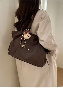 Model view of a large brown tote bag with a cute bear charm and a polka dot bow