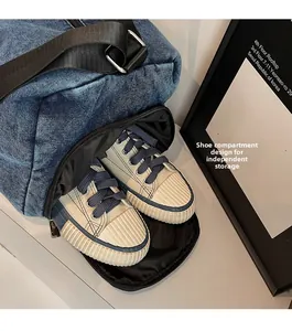 Detail view of the deep blue denim tote bag showing its side independent shoe compartment