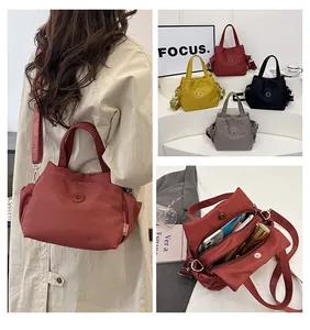Détails du sac seau en nylon léger montrant les compartiments et la bandoulière large