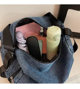 Spacious interior of denim tote bag showing items like water bottle and umbrella