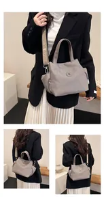 Détail du sac seau gris avec bandoulière large à logo et poches latérales pour femme
