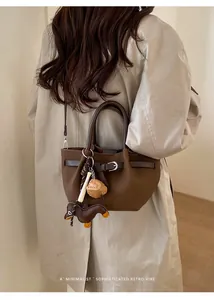 Detail der dunkelbraunen Leder-Einkaufstasche mit Dackel-Anhänger und Mini-Taschen-Zubehör