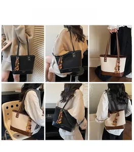 Detail view of stylish tote bag with wooden bead tassel and contrast stitching accents