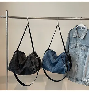 Detailed view of large capacity denim hobo bags in dark grey and blue with wide straps