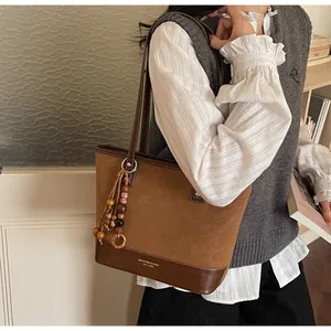 Brown suede patchwork tote bag with beaded tassel and MIKAXIQI logo detail