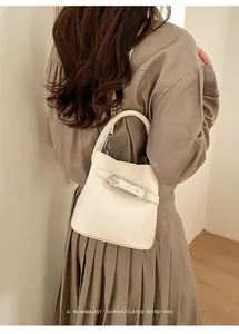 Minimalist beige bucket bag with silver clasp shown in a sophisticated lifestyle setting