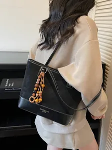 Minimalist black faux leather tote bag with wooden bead charm for women's daily commute