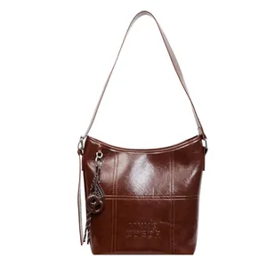 Dark brown high-gloss leather tote bag with embossed letters and tassel ornament