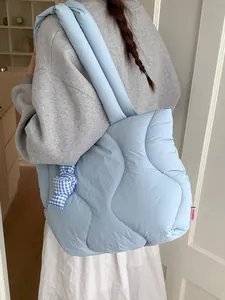 Light blue quilted puffer tote bag with ribbon detail for women's daily commute
