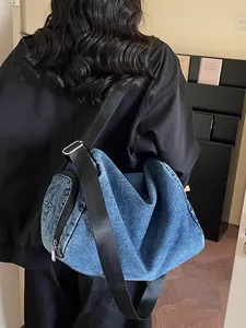 Washed blue denim tote bag with star-stitched side pocket and adjustable wide strap