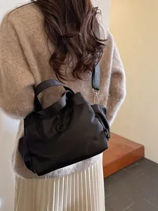 Sac seau en nylon noir avec bandoulière réglable porté à l'épaule par le mannequin