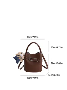 Brown lychee leather bucket bag with silver clip and bear charm in front view