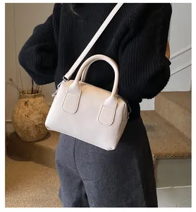 Vue de dos d'un mannequin portant un sac Boston beige, montrant sa taille et son style