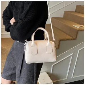 Détail de la texture motif lychee beige sur un sac Boston avec finitions en métal argenté