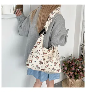 Detail view of beige canvas tote bag with colorful cartoon horse print and ruched shoulder strap
