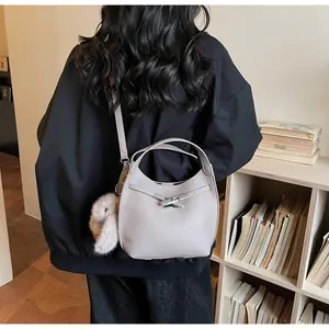 Detailed texture of grey lychee leather bucket bag with cute plush rabbit charm