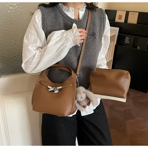 Close-up of brown litchi pattern bucket bag and pouch with a cute bunny charm