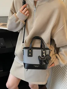Minimalist color-block bucket bag in grey and black leather with cute puppy charm