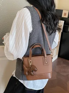 Contrast color bucket bag in leather and canvas with dog charm and long shoulder strap