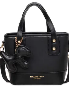 Black bucket bag with top handles, brand lettering, and a cute dog charm attachment