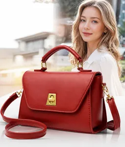 Détail du sac à main en cuir mat rouge avec fermoir doré et bandoulière réglable