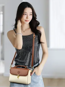 Minimalist beige and brown crossbody bag with gold buckle on a stylish model