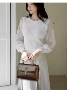 Minimalist brown pebbled leather baguette bag with a gold metal clasp and top handle
